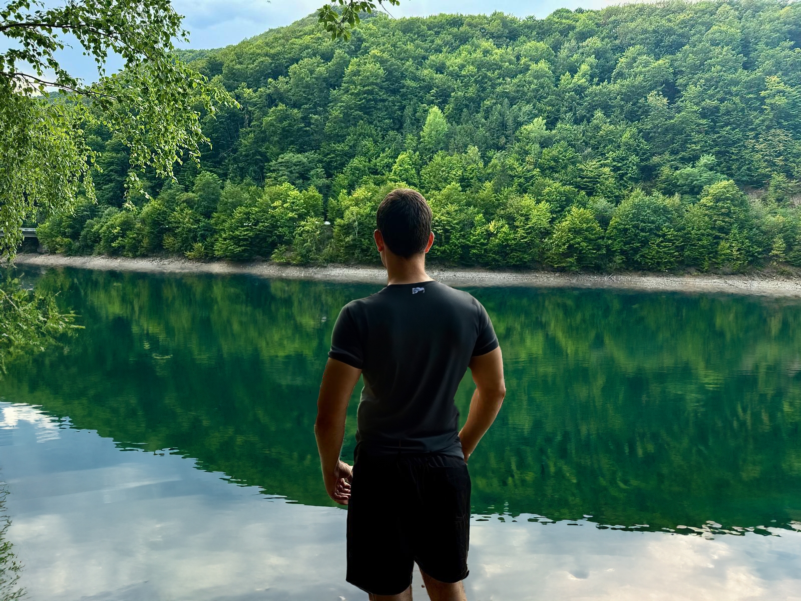 Man looking at a lake with kayaks